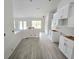 Open-concept kitchen with sleek white cabinets, a breakfast bar, and modern gray flooring at 507 San Ambrosio St, Punta Gorda, FL 33983