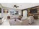 Bright living room with a ceiling fan, large windows and rustic wood accent wall at 1190 Victoria Ave Nw, Port Charlotte, FL 33948