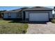 Charming single-story home featuring a brick driveway and a two-car garage at 12051 Crossgate Ave, Port Charlotte, FL 33981