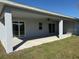 Covered patio featuring concrete flooring, sliding glass doors, a ceiling fan, and a grassy lawn at 12051 Crossgate Ave, Port Charlotte, FL 33981
