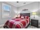 Simple bedroom with a red plaid comforter and dark wood furniture at 12750 Oriago St, Venice, FL 34293