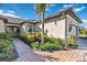 Brick-paved walkway leading to a light beige house with lush landscaping at 12750 Oriago St, Venice, FL 34293