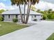 Gray house with metal roof, long driveway, and palm trees at 1298 Waterside St, Port Charlotte, FL 33952