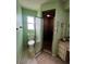 Green bathroom featuring a toilet, vanity, medicine cabinet, and tiled stand-up shower with a glass door at 1438 Razorbill Ln, Punta Gorda, FL 33983