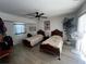 Bright bedroom with two beds, ceiling fan, and a plant near a sunlit window at 1438 Razorbill Ln, Punta Gorda, FL 33983