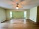Empty living room space featuring laminate floors, bay windows, and a ceiling fan at 1438 Razorbill Ln, Punta Gorda, FL 33983