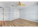 Spacious bedroom with wood-look flooring, white closet doors, and a ceiling fan at 1600 W Marion Ave # 234, Punta Gorda, FL 33950