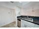 Kitchen with stainless steel appliances, a dark countertop, white cabinets, and tile floor at 19505 Quesada Ave # M205, Port Charlotte, FL 33948