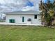 Back view of the house with a concrete patio and green lawn at 200 Dolphin Pkwy, Punta Gorda, FL 33950
