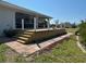 Spacious wooden deck with white rope railing, outdoor seating area, and well-maintained landscaping at 200 Dolphin Pkwy, Punta Gorda, FL 33950