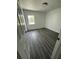 Bright bedroom featuring modern gray flooring, white walls, a window, and a flush mount ceiling light at 200 Dolphin Pkwy, Punta Gorda, FL 33950