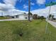 Side view of a house with a two-car garage and a green lawn at 200 Dolphin Pkwy, Punta Gorda, FL 33950