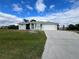 Charming single-story home with a paved driveway and lush green lawn at 200 Dolphin Pkwy, Punta Gorda, FL 33950