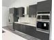 Sleek, modern kitchen featuring dark cabinets, stainless steel appliances, and white countertops at 200 Dolphin Pkwy, Punta Gorda, FL 33950
