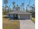 Single-story home with gray roof, paver driveway, and landscaping at 2364 Hagerick Ln, North Port, FL 34288
