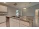 A close up of a kitchen island with stone counters and sink, next to stainless steel dishwasher at 2364 Hagerick Ln, North Port, FL 34288