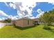 Backyard with green grass, a large tree, and a white fence at 2507 Hobblebrush Dr, North Port, FL 34289