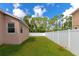 Backyard with green grass, a white fence, and a glimpse of the house at 2507 Hobblebrush Dr, North Port, FL 34289