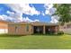 Spacious backyard with covered patio, lush grass and a partially visible house at 2507 Hobblebrush Dr, North Port, FL 34289