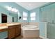 Bathroom with soaking tub, walk-in shower, and light blue walls at 2507 Hobblebrush Dr, North Port, FL 34289