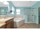 Spa-like bathroom with soaking tub, walk-in shower, and light blue walls at 2507 Hobblebrush Dr, North Port, FL 34289