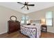 Bedroom with floral bedding, wood dresser, and ceiling fan at 2507 Hobblebrush Dr, North Port, FL 34289