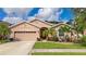 Single-story house with beige exterior, palm trees, and a well-manicured lawn at 2507 Hobblebrush Dr, North Port, FL 34289