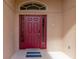 Red front door entry with sidelights and a decorative doormat at 2507 Hobblebrush Dr, North Port, FL 34289