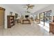 Living room with tile floors, ceiling fans, and large windows offering pool views at 264 Rotonda N Blvd, Rotonda West, FL 33947