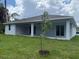 A backyard view featuring a covered patio and green lawn at 290 Overbrook St, Port Charlotte, FL 33954