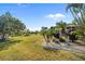 Large grassy backyard with mature trees and tropical landscaping at 3026 Guadalupe Dr, Punta Gorda, FL 33950