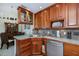Bright kitchen with wood cabinets, stainless steel appliances, and tile countertops at 3300 Loveland Blvd # 3103, Punta Gorda, FL 33980