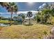 Lush green backyard with palm trees and a water view at 3404 Depew Ave, Port Charlotte, FL 33952