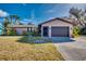 Front exterior view of a single-story home with a two-car garage at 3404 Depew Ave, Port Charlotte, FL 33952