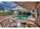 Inviting screened-in pool area with a patio table and surrounding trees at 3404 Depew Ave, Port Charlotte, FL 33952
