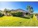 Lush, green lawn, screened-in lanai, and privacy hedges in backyard at 3700 Candia Dr, Punta Gorda, FL 33950