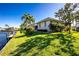Tropical backyard with lush lawn, palm trees, and private dock at 3700 Candia Dr, Punta Gorda, FL 33950