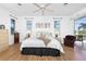 Bright bedroom with a ceiling fan, sliding glass doors, and wood-look floors at 3700 Candia Dr, Punta Gorda, FL 33950