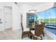 Bright breakfast nook with wicker chairs, glass-top table, and serene pool views at 3700 Candia Dr, Punta Gorda, FL 33950