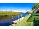 Private dock overlooking a serene canal, surrounded by lush greenery at 3700 Candia Dr, Punta Gorda, FL 33950
