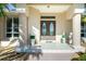 Covered front entry with double doors, tile flooring, columns, and decorative potted plants at 3700 Candia Dr, Punta Gorda, FL 33950