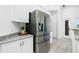 Kitchen with stainless steel refrigerator, white cabinetry, and granite countertops at 3700 Candia Dr, Punta Gorda, FL 33950