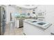 Modern kitchen with white cabinetry, stainless steel appliances, and an island cooktop at 3700 Candia Dr, Punta Gorda, FL 33950