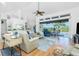 Living area with a ceiling fan, high ceilings, wood floors, and sliding glass doors that lead to a patio at 3700 Candia Dr, Punta Gorda, FL 33950