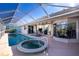 Inviting pool and spa with a screened enclosure and view of the home at 3700 Candia Dr, Punta Gorda, FL 33950