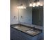 Dual vanity bathroom with granite countertops, large mirror, and modern light fixtures at 384 Prineville St, Port Charlotte, FL 33954