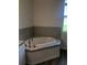 Modern bathroom featuring a soaking tub, tile surround, and brushed nickel fixtures at 384 Prineville St, Port Charlotte, FL 33954