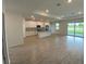 Open-concept kitchen and living area with white cabinets, stainless steel appliances, and tile floors at 384 Prineville St, Port Charlotte, FL 33954