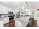 Bright, spacious kitchen featuring white cabinetry, stainless steel appliances, and a granite countertop island at 4695 Kennett St, North Port, FL 34288