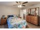 Bedroom with floral bedding, ceiling fan, and wooden dresser at 5325 Cillette Ave, North Port, FL 34288
